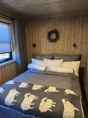 a bedroom with a bed with a blanket on it at Ny hytte med panoramautsikt in Hjartdal