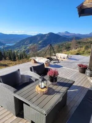 a patio with a table and chairs on a deck at Ny hytte med panoramautsikt in Hjartdal