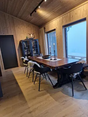 a dining room with a large wooden table and chairs at Ny hytte med panoramautsikt in Hjartdal