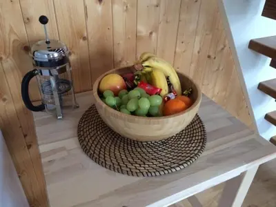 a wooden bowl of fruit on a table at Gårdsleilighet in Verdal