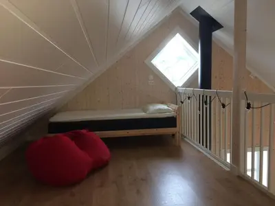 a room with a bed in the attic with a window at Gårdsleilighet in Verdal