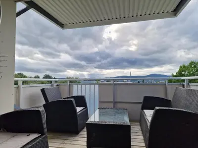 a patio with chairs and a table on a balcony at Private Room in a shared Apartment with Mountain Views & Greenery in Trondheim