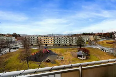 a view of a building with a playground in a park at Private Room in a shared Apartment with Mountain Views & Greenery in Trondheim