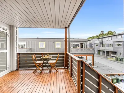 a patio with a table and chairs on a deck at Nice apartment with sea view in Trondheim