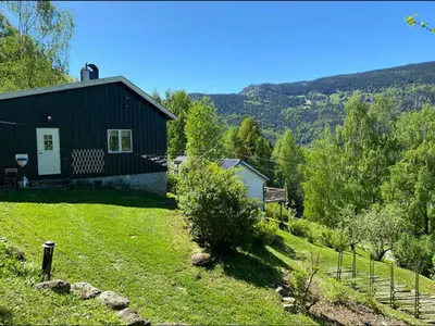 a small black house in the middle of a yard at Charming family house near Kvitfjell in Ringebu