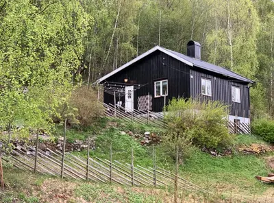 a black house in the middle of a forest at Charming family house near Kvitfjell in Ringebu