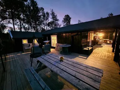 a wooden deck with a swing and a house at Trivelig hytte med innlagt strøm og vann Perfekt for familietur Bilveg helt frem in Rotvolden