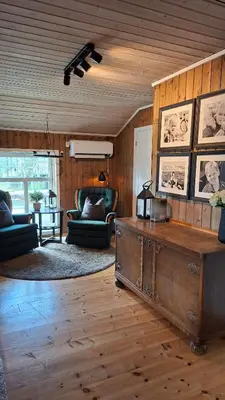 a living room with a table and a wooden ceiling at Trivelig hytte med innlagt strøm og vann Perfekt for familietur Bilveg helt frem in Rotvolden