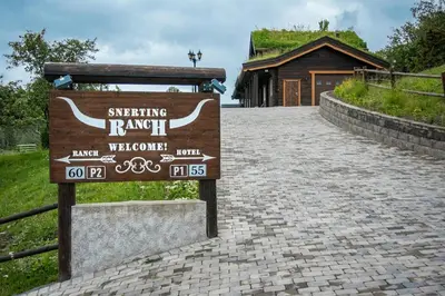 a sign on a brick road in front of a building at Snerting Ranch Hotel - Comfty and modern Log House in Stokkan