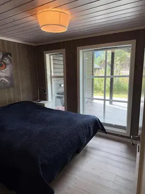 a bedroom with a bed and a large window at New cottage near the city center and ski slope in Hemsedal