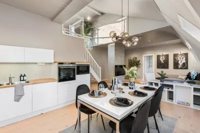a kitchen and dining room with a table and chairs at Two bedroom penthouse with large living room and rooftop in the city centre of Trondheim in Trondheim