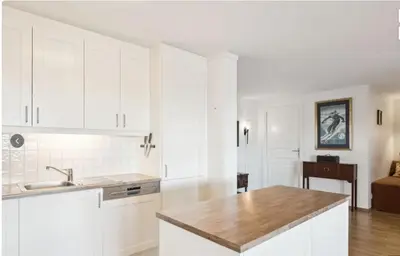 a kitchen with white cabinets and a wooden counter top at Family Friends, 3 Bedroom Apartment With Terrace in Beitostøl