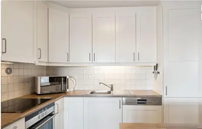 a kitchen with white cabinets and a sink and a microwave at Family Friends, 3 Bedroom Apartment With Terrace in Beitostøl