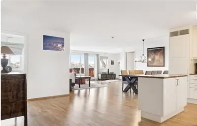 a kitchen and living room with white cabinets and a table at Family Friends, 3 Bedroom Apartment With Terrace in Beitostøl