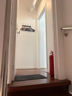 a hallway with a door and a red suitcase at In the middle of Bergen City in a real Bergenshus from the 18th Century in Bergen