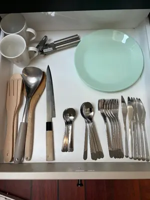 a drawer filled with silver utensils on a counter at In the middle of Bergen City in a real Bergenshus from the 18th Century in Bergen