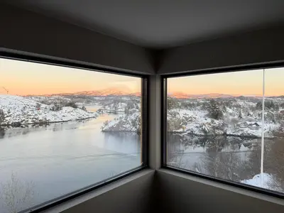 two windows in a room with a view of a river at Modern detached house with a view in Arefjord