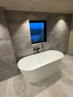 a white bath tub in a bathroom with a window at Modern detached house with a view in Arefjord