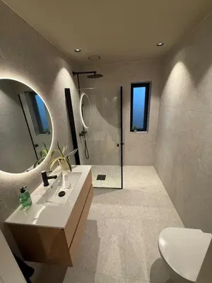 a bathroom with a sink and a mirror and a shower at Modern detached house with a view in Arefjord