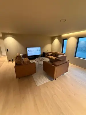 a living room with two couches and a flat screen tv at Modern detached house with a view in Arefjord