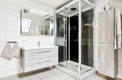a white bathroom with a shower and a sink at Spacious 3-Bedroom Apartment with Balcony and Free Parking Orkland near Trondheim in Fannrem