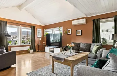 a living room with a couch and a tv at Spacious 3-Bedroom Apartment with Balcony and Free Parking Orkland near Trondheim in Fannrem