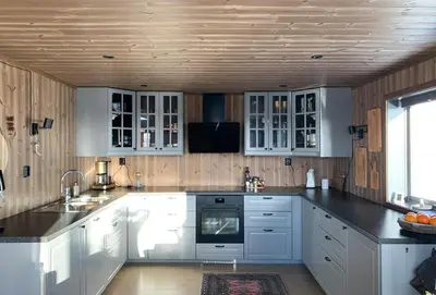 a kitchen with white cabinets and a stove top oven at Stylish Cabin With Lovely View At Stavadalen in Reinli