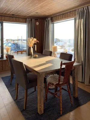 a dining room with a wooden table and chairs at Stylish Cabin With Lovely View At Stavadalen in Reinli