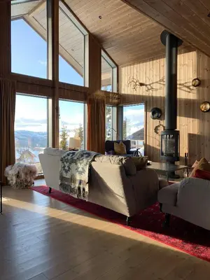 a bedroom with a bed and a couch and windows at Stylish Cabin With Lovely View At Stavadalen in Reinli