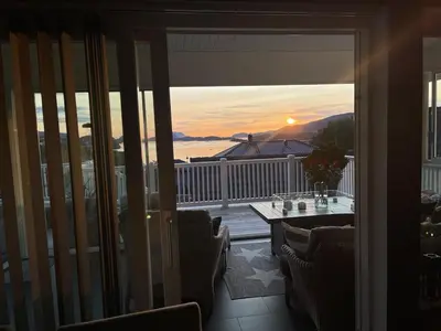 a room with a balcony with a view of the sunset at Casa Oyen in Ålesund
