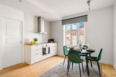 a kitchen with a table and green chairs in a room at Authentic Bergen Charm in Famous Neighborhood in Bergen