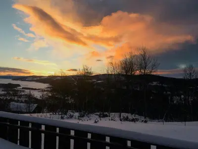 a view of a sunset from a balcony with snow at Mountain Cabin With Views Over Storevann in Hemsedal