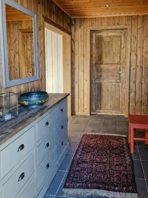 a bathroom with a dresser with a mirror and a door at Mountain Cabin With Views Over Storevann in Hemsedal