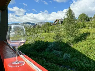 a glass of wine sitting on a window sill at Spacious Apartment By Hardangervidda National Park in Ustaoset
