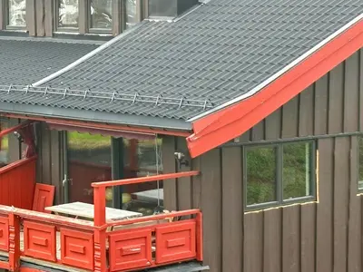 a metal roof on a house with a red porch at Spacious Apartment By Hardangervidda National Park in Ustaoset