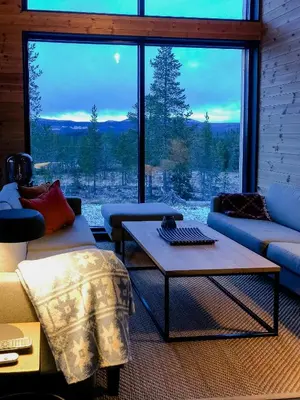 a living room with couches and a table and a large window at Modern Cabin With Views Of Trysil Mountain in Trysil
