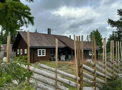 a wooden house with a fence in front of it at Family Cabin With Charm in Mesnali