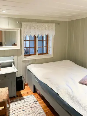 a bedroom with a bed and a sink and a window at Family Cabin With Charm in Mesnali