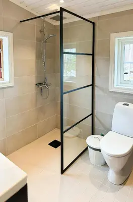 a bathroom with a toilet and a glass shower at Family Cabin With Charm in Mesnali