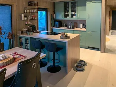 a kitchen with blue cabinets and a table with chairs at Modern Cabin Close To The Ski Slopes In Haglebu in Eggedal