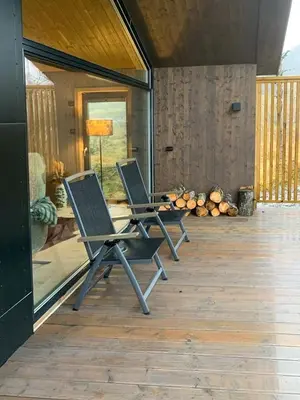 two chairs sitting on a wooden deck in a house at Modern Cabin Close To The Ski Slopes In Haglebu in Eggedal
