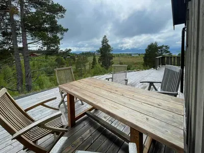 a wooden table and chairs on a deck at Family Cabin In Rauland in Rauland