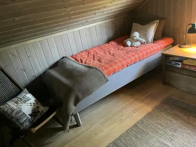 a teddy bear sitting on a bed in a room at Modern Cabin With Views Of Skeikampen in Svingvoll
