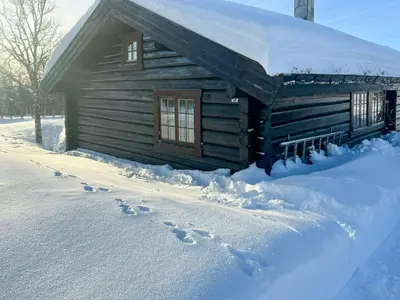 a log cabin with footprints in the snow at Traditional Log Cabin At Reineskarvet in Ål