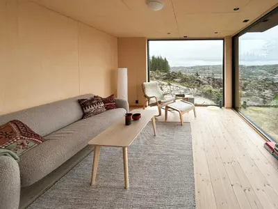a living room with a couch and a table at Architect-Designed Cabin Panoramic View in Ervik