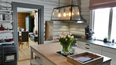 a kitchen with a vase of flowers on a table at Historic Hunting Lodge By Lake Øyangen in Gålå