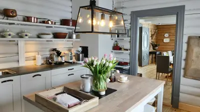 a kitchen with a table with a vase of flowers at Historic Hunting Lodge By Lake Øyangen in Gålå