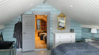 a bedroom with blue walls and a bed and a mirror at Historic Hunting Lodge By Lake Øyangen in Gålå