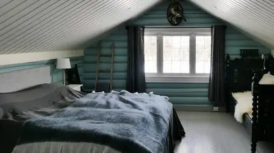 a bedroom with a bed with blue walls and a window at Historic Hunting Lodge By Lake Øyangen in Gålå