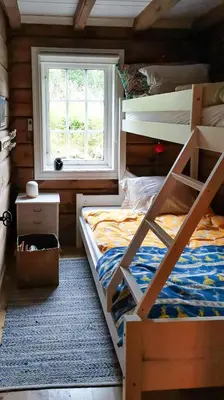a bedroom with two bunk beds and a window at Timber Cabin With Soul At Kvamskogen in Norheimsund